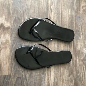 Shiny black flip flops